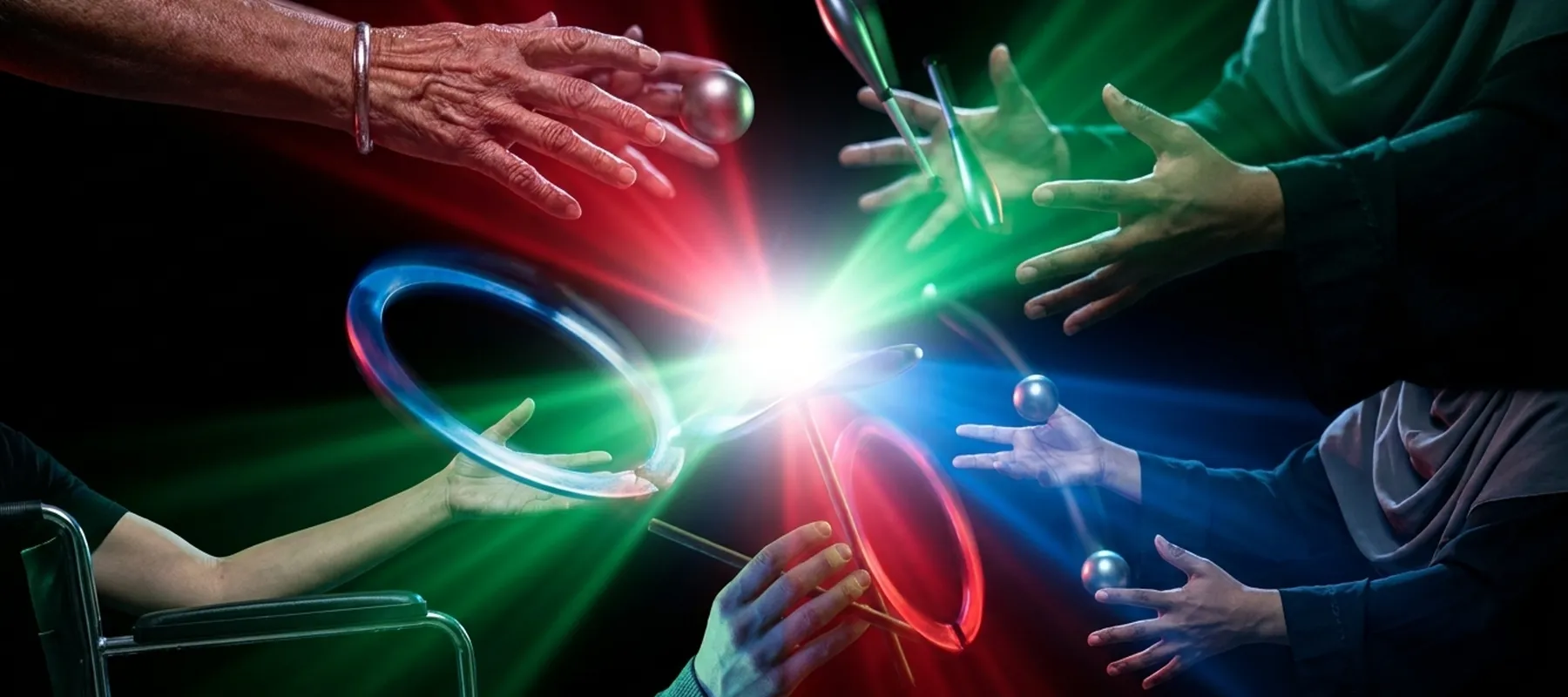 Multiple hands reaching toward a center point where rings, balls, and clubs converge in RGB light