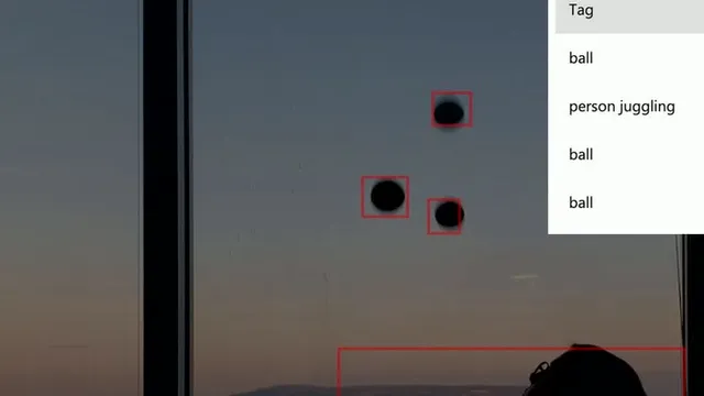A juggler mid-throw in front of a window, with Azure Custom Vision bounding boxes visible around the body and ball in the detection overlay