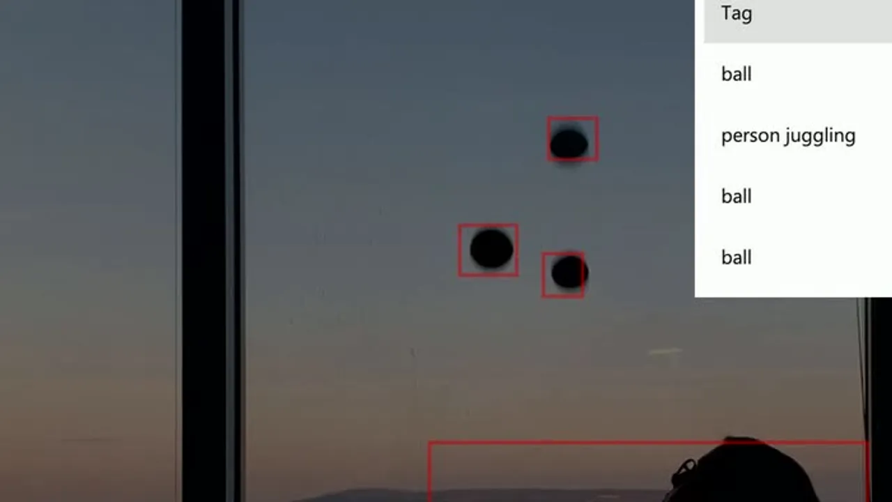 A juggler mid-throw in front of a window, with Azure Custom Vision bounding boxes visible around the body and ball in the detection overlay